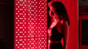 a woman standing with red light therapy