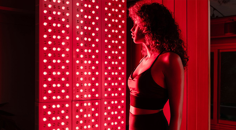 a woman standing with red light therapy